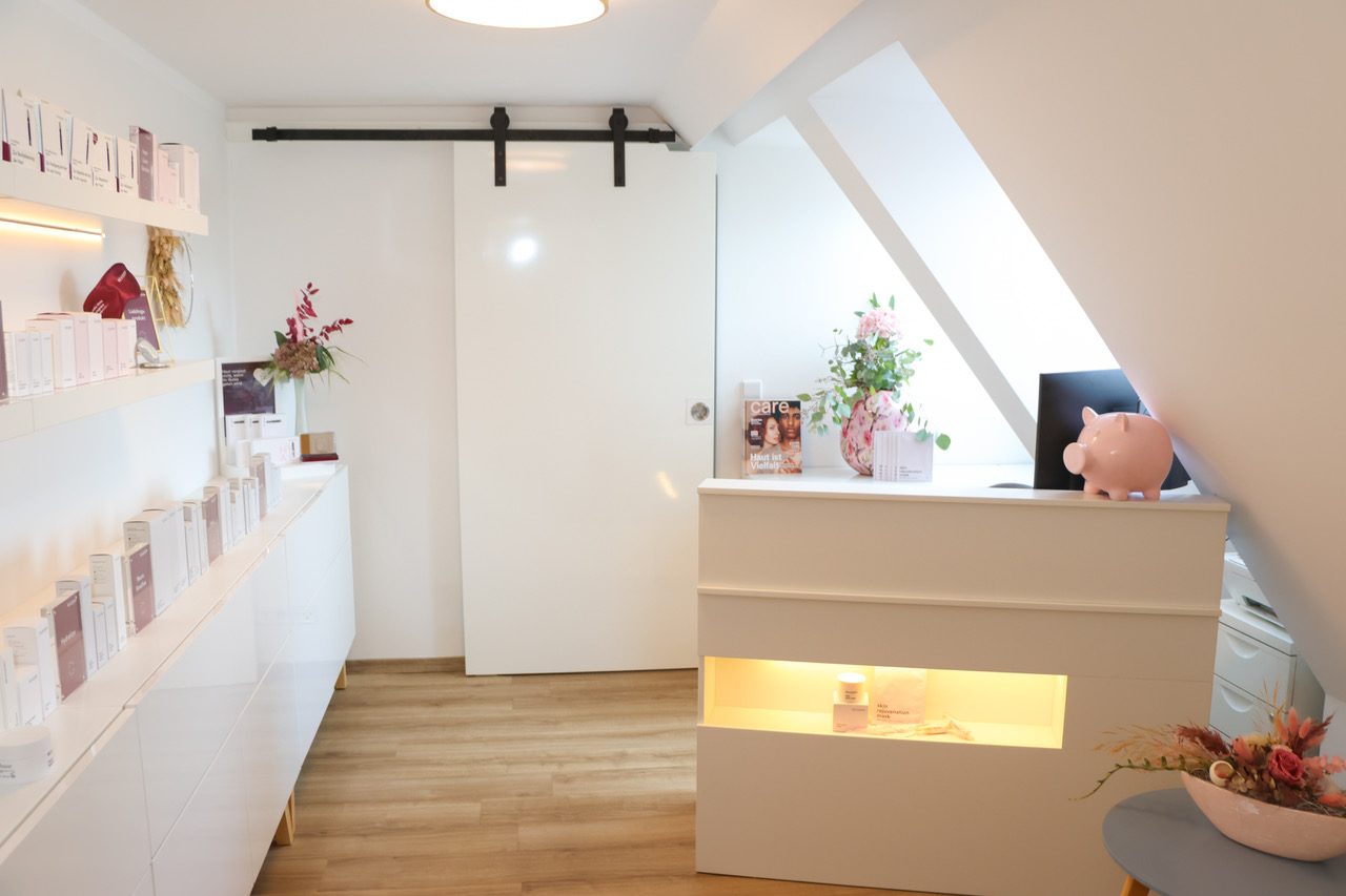 Empfangsbereich von hautconcept mit Produktregal und heller Behandlungstheke